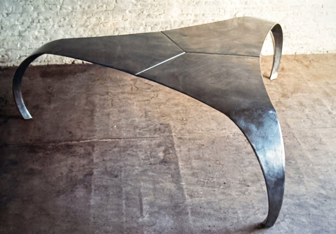 La table de trois quarts, pieds enroulés au sol